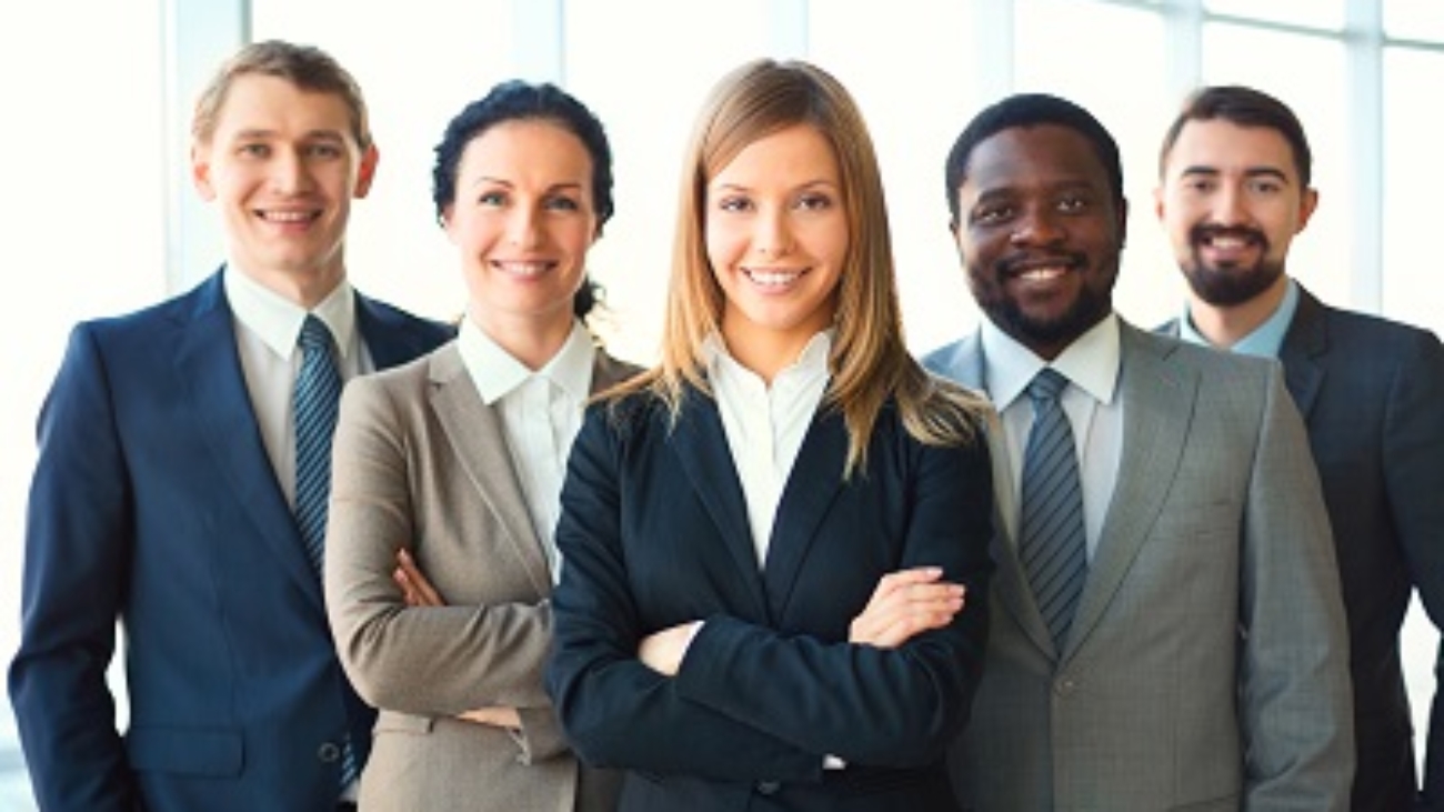 Group of business partners looking at camera with smiles, pretty leader in front